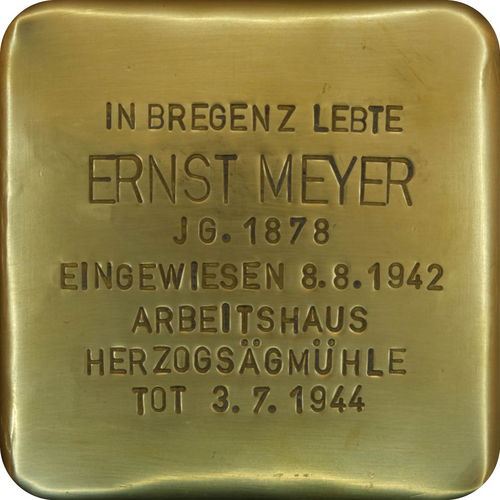 Das Bild zeigt einen sogenannten "Stolperstein". Die Steine tragen auf der Oberseite kleine Messingplatten mit dem Namen von Opfern der NS-Diktatur und werden vor deren einstigen Wohnungen im Straßen- oder Gehwegpflaster verlegt.