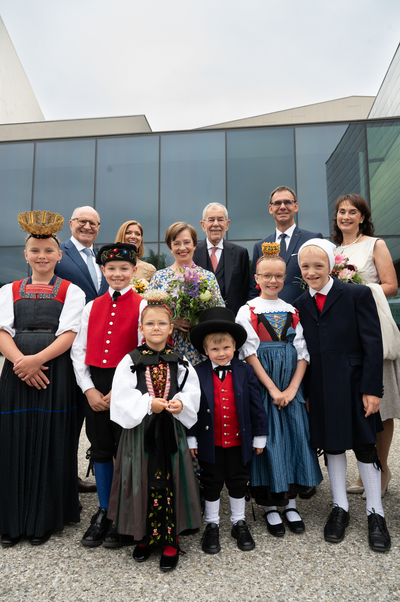 Das Bild zeigt die Prominenz aus Bregenz und ganz Österreich bei der Eröffnung der 78. Bregenzer Festspiele am Festspielareal. Vorne im Bild sind die traditionellen Kindertrachtenpaare zu sehen.