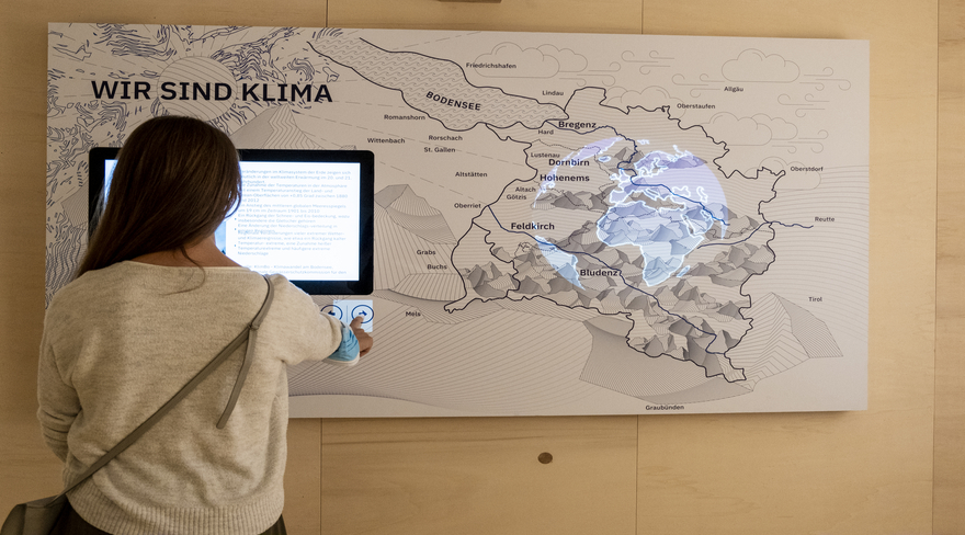 Diese Abbildung zeigt eine Bürgerin vor einem interaktiven Kunstwerk.