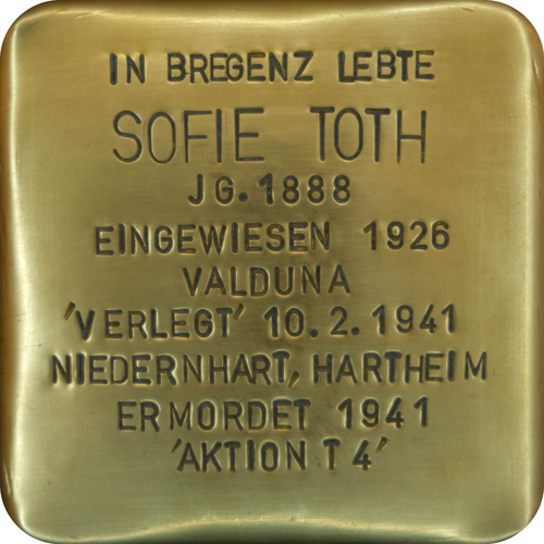 Das Bild zeigt einen sogenannten "Stolperstein". Die Steine tragen auf der Oberseite kleine Messingplatten mit dem Namen von Opfern der NS-Diktatur und werden vor deren einstigen Wohnungen im Straßen- oder Gehwegpflaster verlegt.