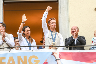 Das Bild zeigt die Segler:innen Lara Vadlau und Lukas Mähr auf dem Rathausbalkon. © Udo Mittelberger