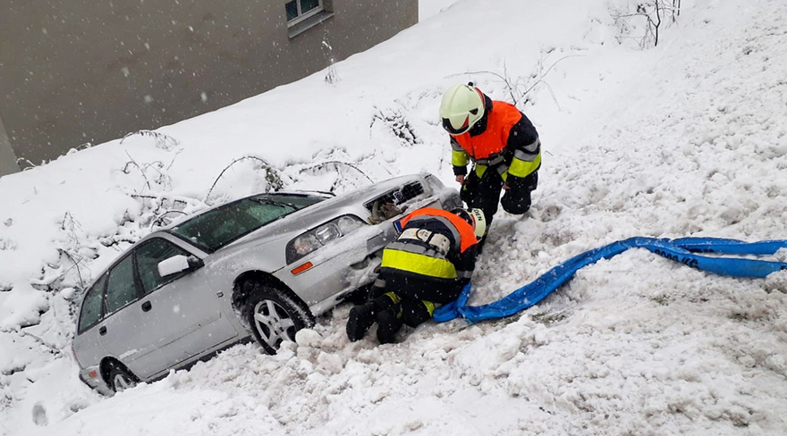 Diese Abbildung zeigt zwei Männer, welche die Bergung eines Fahrzeuges im Schnee vorbereiten.