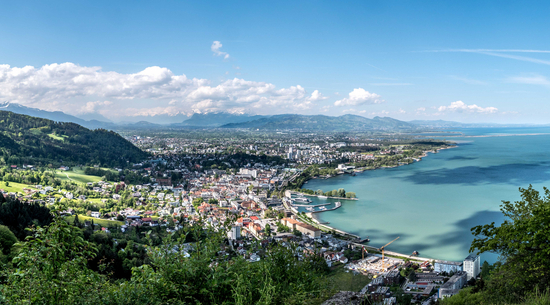 Das Bild zeigt ein Panoramafoto der Stadt Bregenz mit dem Bodensee. 