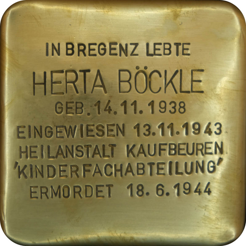 Das Bild zeigt einen sogenannten "Stolperstein". Die Steine tragen auf der Oberseite kleine Messingplatten mit dem Namen von Opfern der NS-Diktatur und werden vor deren einstigen Wohnungen im Straßen- oder Gehwegpflaster verlegt.