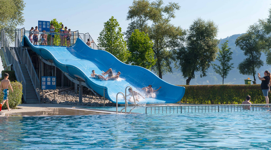 Hier ist die große Wasserrutsche des Bregenzer Strandbades mit Kindern und Jugendlichen zu sehen.