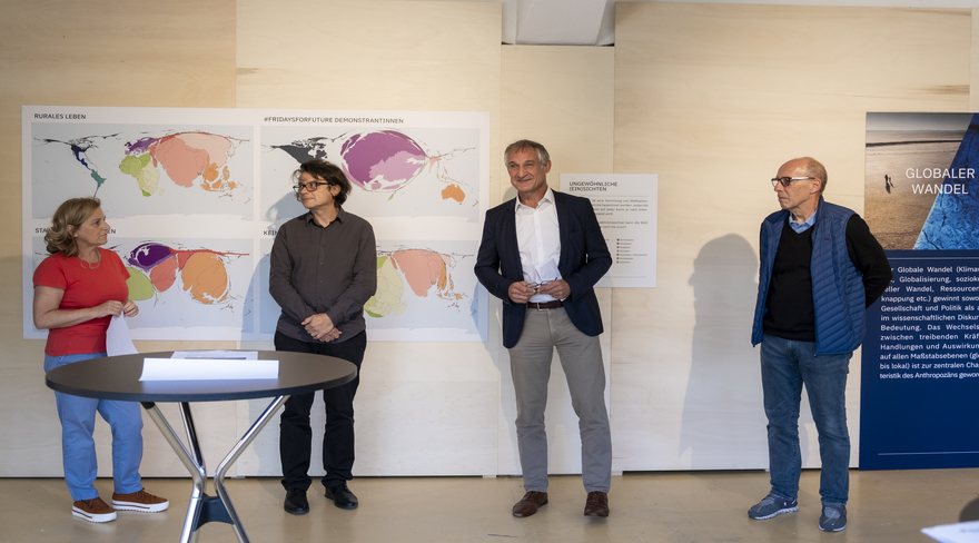Diese Abbildung zeigt Markus Linhart mit Stadtrat Michael Rauth und zwei weiteren Personen bei der Ausstellung "Global Shift".