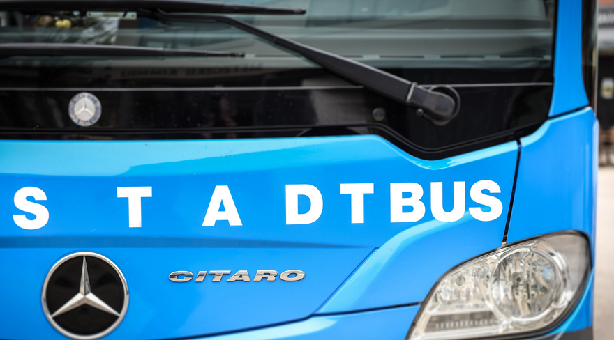 Das Foto zeigt eine Frontalaufnahme der Fahrzeugfront des blauen Bregenzer Stadtbusses mit dem weißen Schriftzug "STADTBUS".