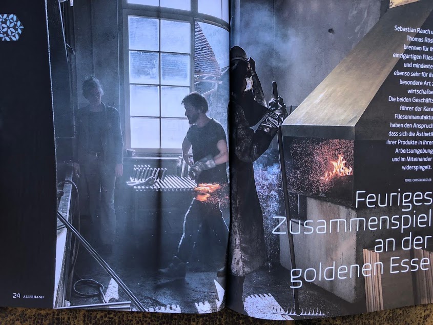 Auf diesem Bild sieht man eine Magazin-Doppelseite. Links stehen zwei Männer in einem Raum mit großen Fenstern, rechts arbeitet ein Mann in Schutzkleidung an einem offenen Feuer. Der Raum ist dunkel und wirkt industriell.